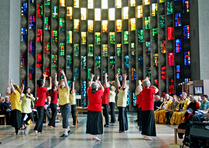 18 dancers in front of stained glass window